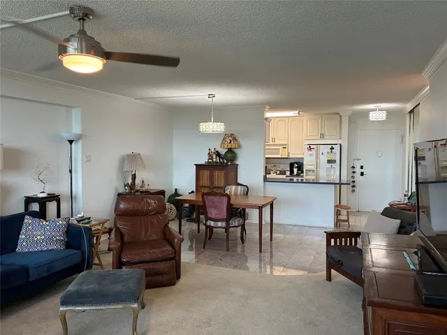 a living room kitchen with furniture and a flat screen tv