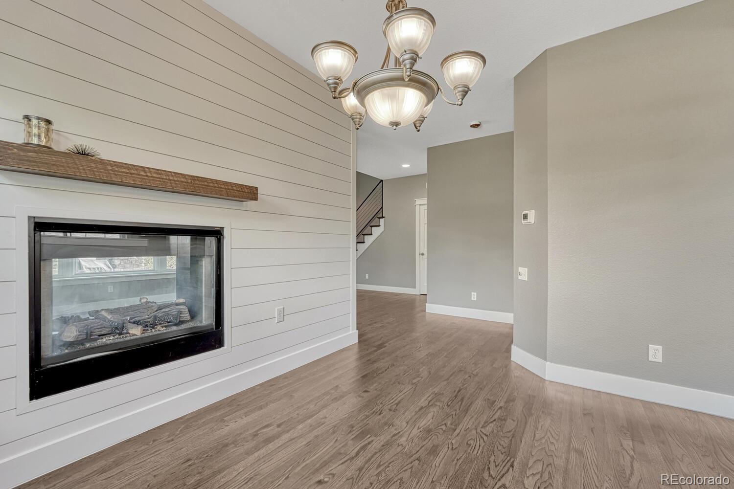 6335 Trailhead Road Highlands Ranch, CO 80130 - Photo 18 of 50 a view of an empty room with wooden floor and a bookshelf
