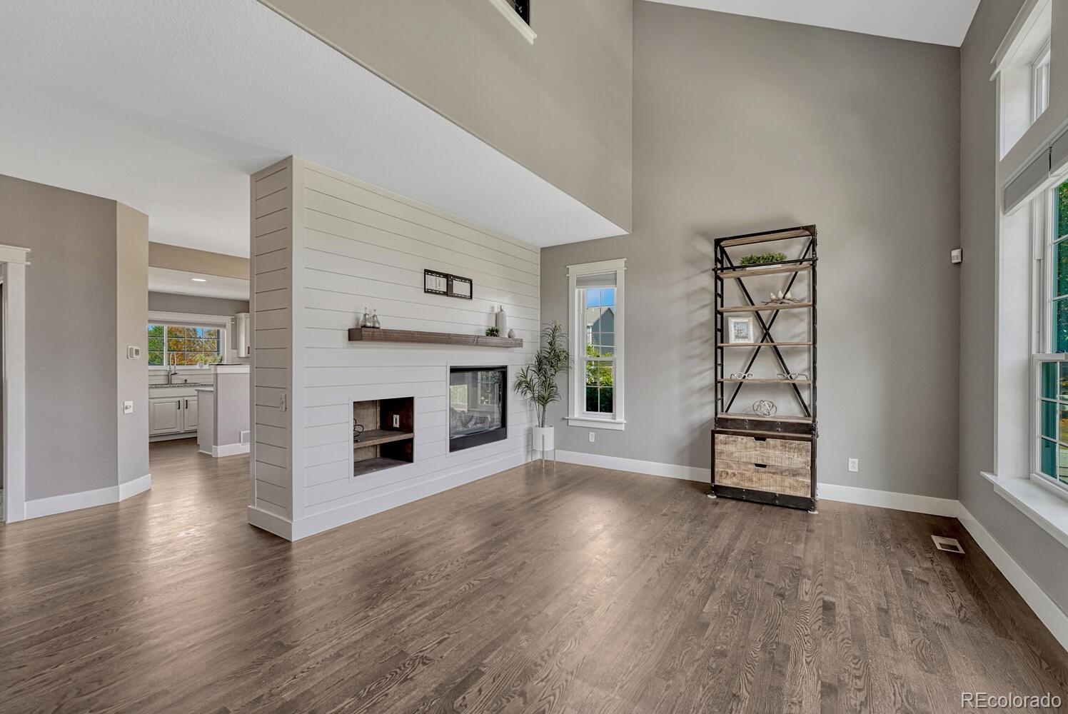 6335 Trailhead Road Highlands Ranch, CO 80130 - Photo 5 of 50 an empty room with wooden floor fireplace and windows