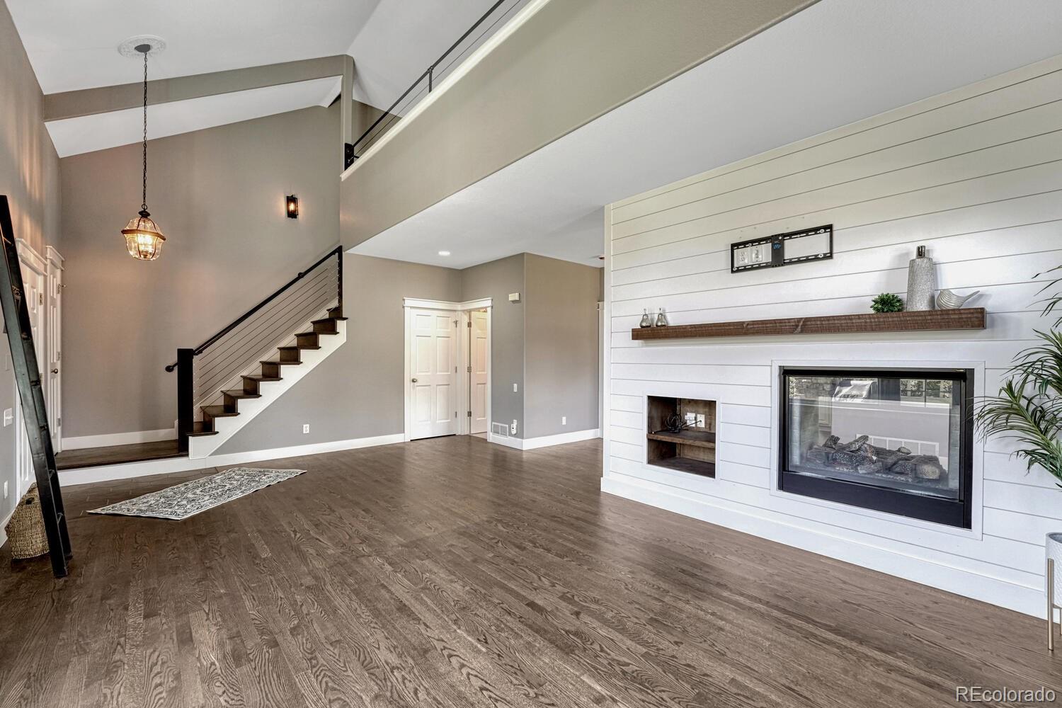 6335 Trailhead Road Highlands Ranch, CO 80130 - Photo 7 of 50 a view of a livingroom with wooden floor and a fireplace