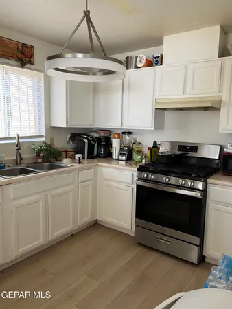a kitchen with granite countertop a stove a sink and a refrigerator