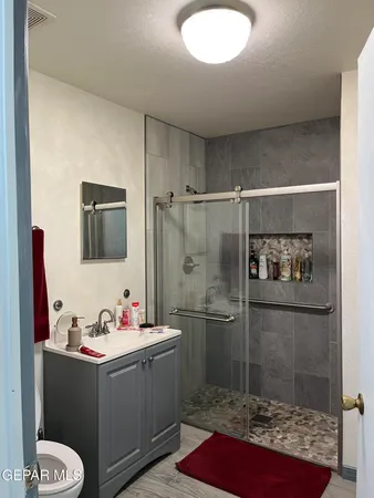 a bathroom with a granite countertop sink mirror and toilet