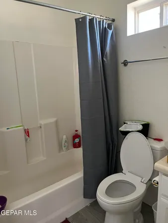 a white toilet sitting next to a bath tub