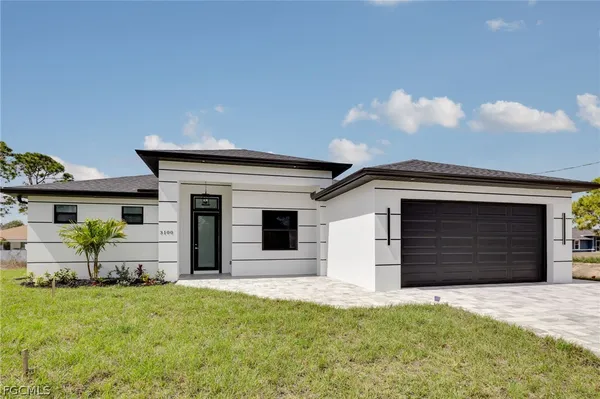 a front view of a house with a yard and garage