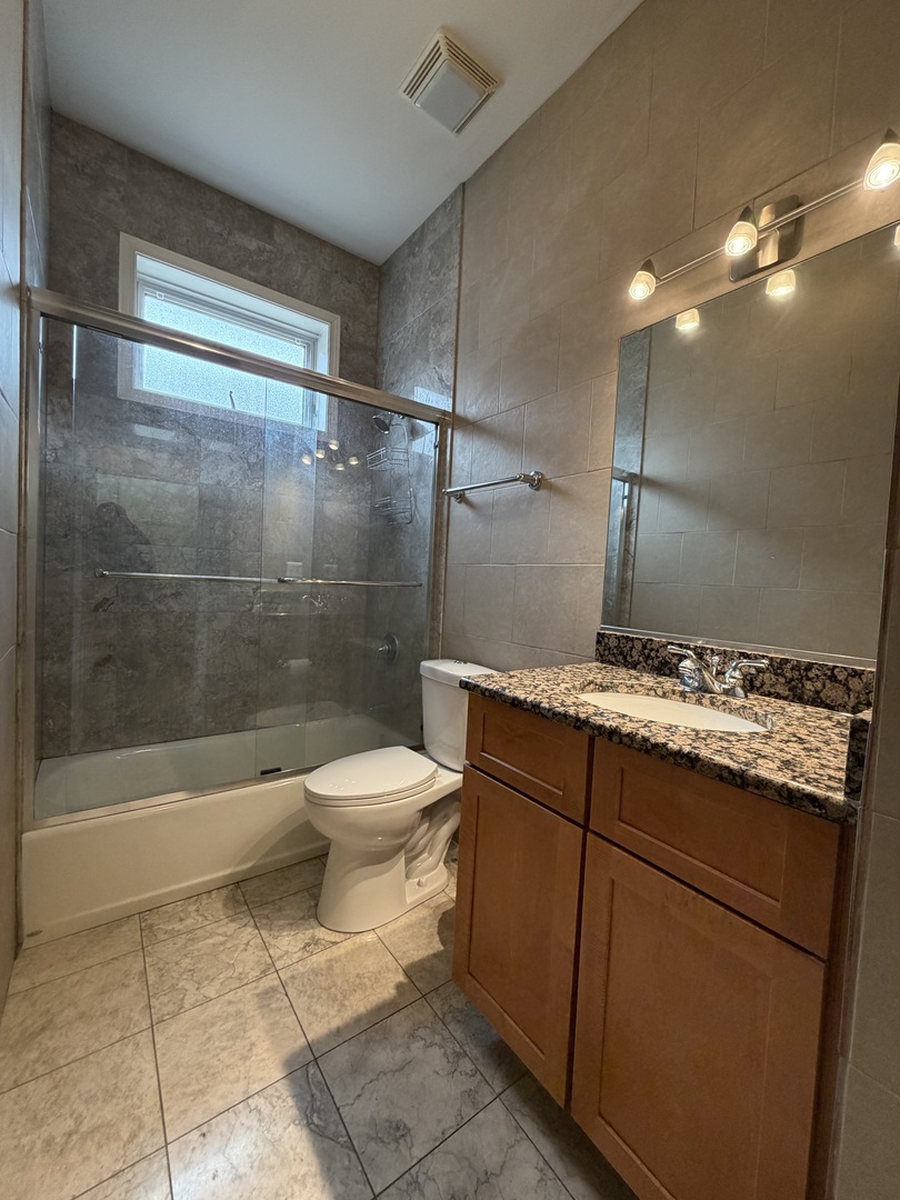 2355 West Harrison Street, Unit GDN Chicago, IL 60612 - Photo 13 of 14 a bathroom with a granite countertop sink a toilet and shower