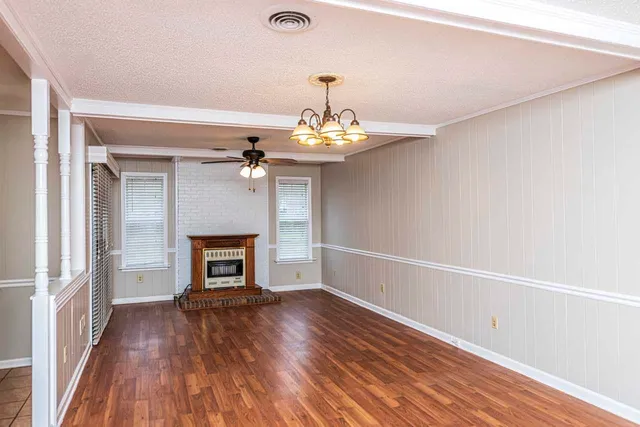 a view of a livingroom with a fireplace wooden floor and a window