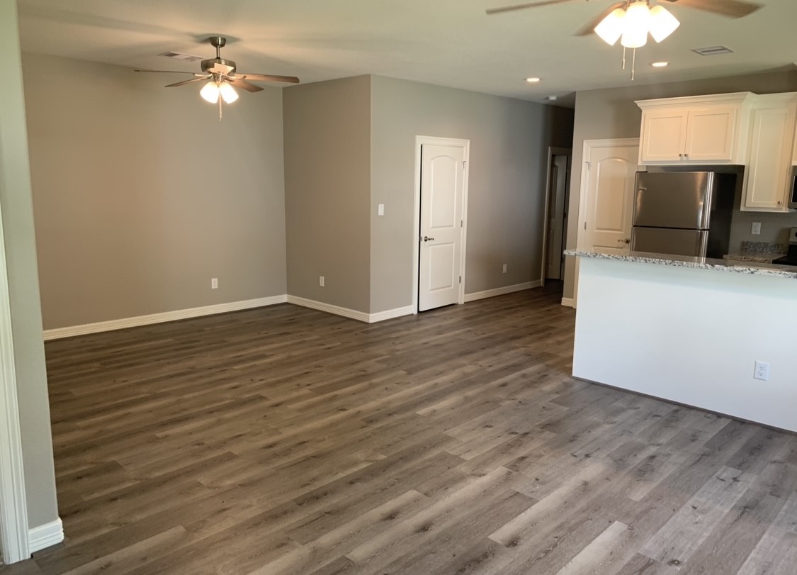 413-415 Hurst Place Angleton, TX 77515 - Photo 13 of 19 a view of a livingroom with a ceiling fan window and wooden floor