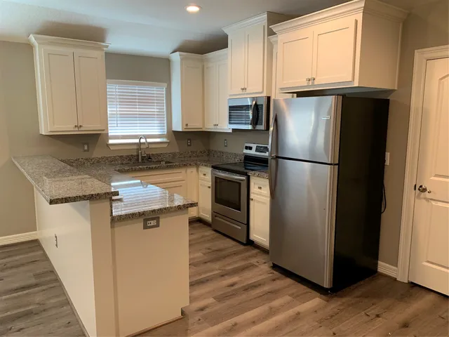 a kitchen with a refrigerator sink and cabinets