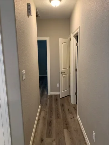 a view of a hallway with wooden floor and closet area