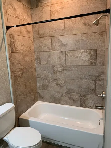 a bathroom with a toilet and a bath tub