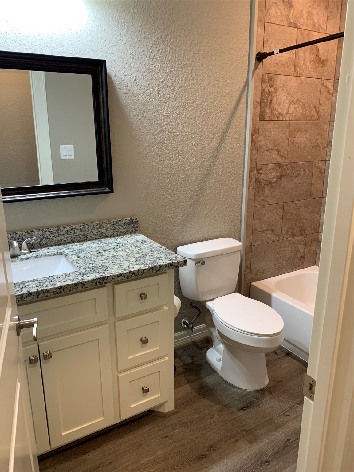 413-415 Hurst Place Angleton, TX 77515 - Photo 7 of 19 a bathroom with a granite countertop toilet sink and mirror