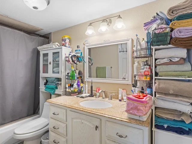 a bathroom with a sink vanity mirror and toilet