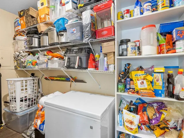 a utility room with fridge dryer and baby toys