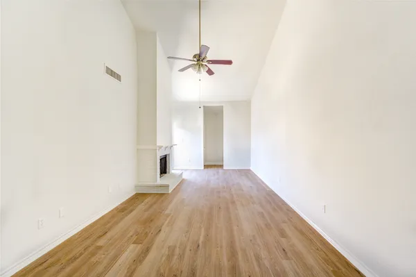 a view of a room with wooden floor ceiling fan