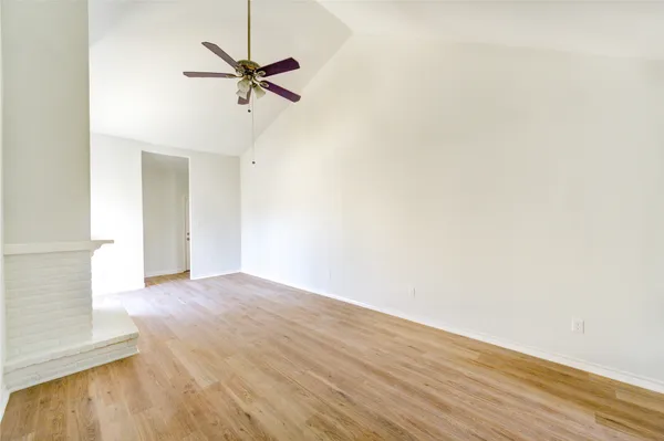 a view of a room with wooden floor and a ceiling fan