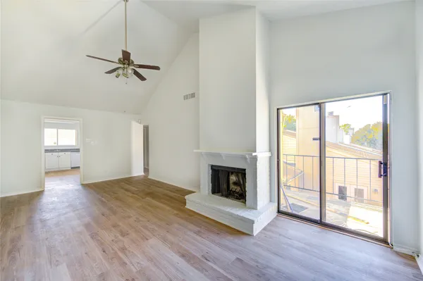 a view of empty room with wooden floor and fireplace