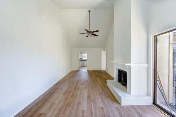 a view of a livingroom with wooden floor and a ceiling fan