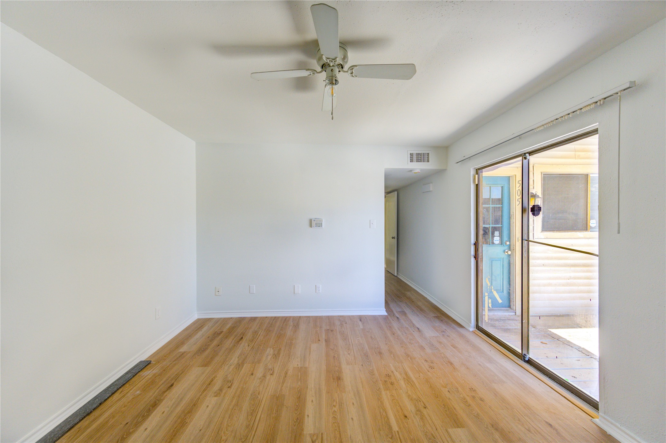 6401 Deihl Road, Unit 505 Houston, TX 77092 - Photo 26 of 35 a view of a room with wooden floor a ceiling fan and windows