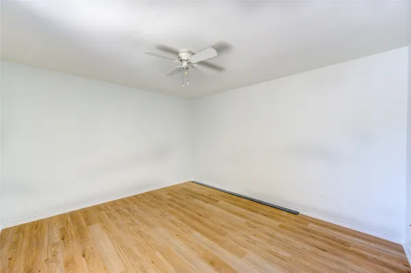 a view of a big room with wooden floor and fan
