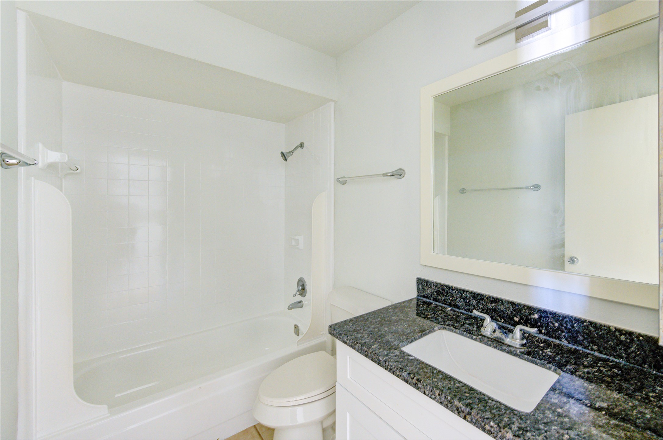 6401 Deihl Road, Unit 505 Houston, TX 77092 - Photo 31 of 35 a bathroom with a granite countertop sink a toilet and shower