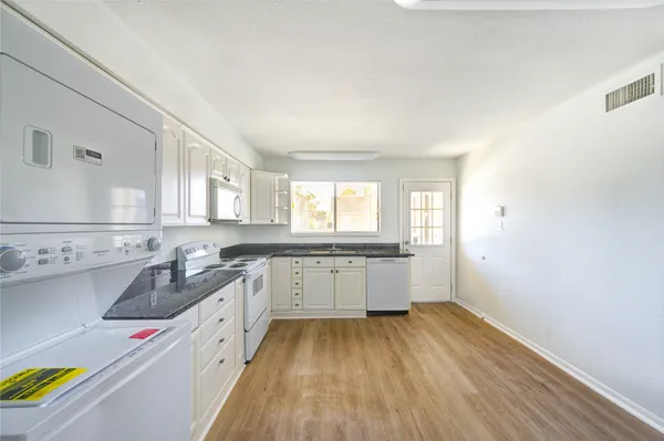 a large kitchen with a wooden floor and cabinets