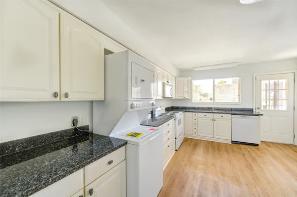 a kitchen with granite countertop a sink and cabinets