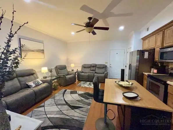 a living room with furniture a flat screen tv and a table