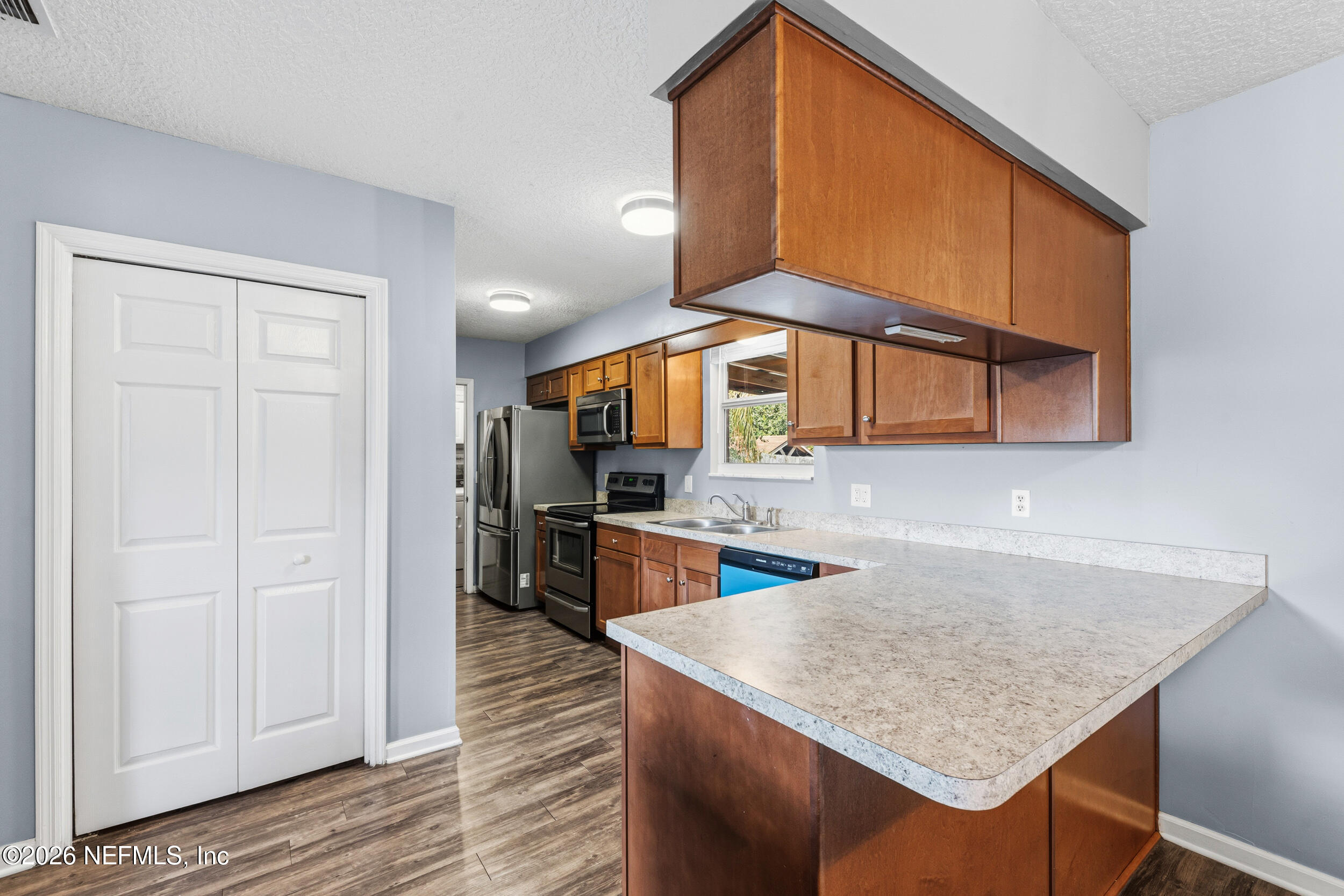 8729 Pinon Drive Jacksonville, FL 32221 - Photo 18 of 33 a kitchen with stainless steel appliances granite countertop a sink refrigerator and cabinets