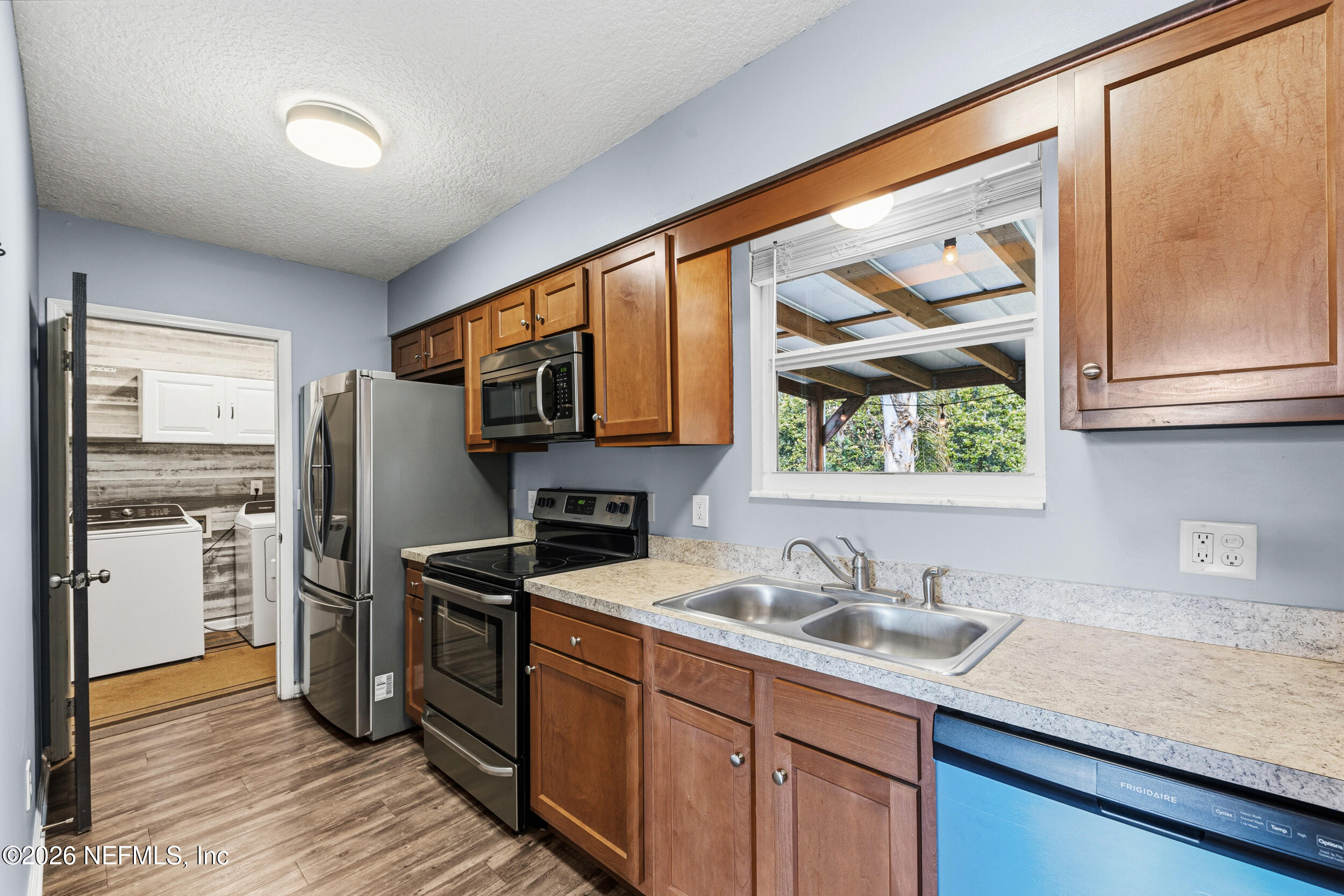 8729 Pinon Drive Jacksonville, FL 32221 - Photo 19 of 33 a kitchen with stainless steel appliances granite countertop a sink stove and refrigerator