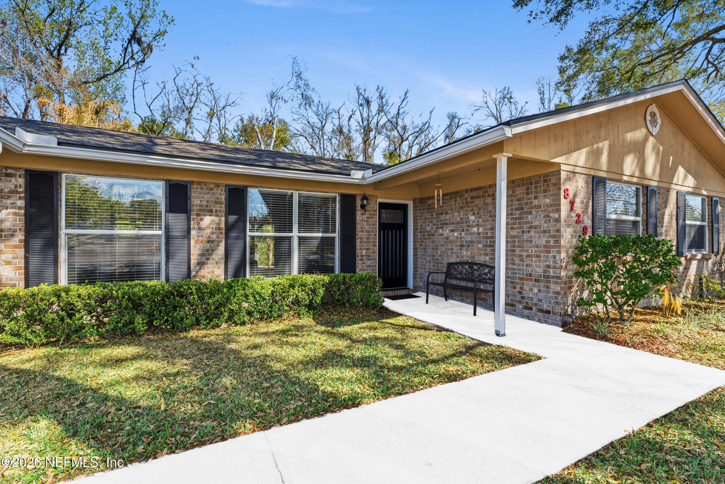 8729 Pinon Drive Jacksonville, FL 32221 - Photo 3 of 33 a view of a house with brick walls and a yard with plants