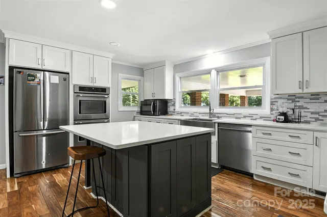 a kitchen with stainless steel appliances granite countertop a sink stove and refrigerator