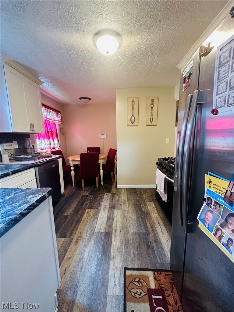 3894 Salisbury Road South Euclid, OH 44121 - Photo 6 of 16 Kitchen with a textured ceiling, stainless steel refrigerator with ice dispenser, dark countertops, hardwood flooring, and white range with gas cooktop