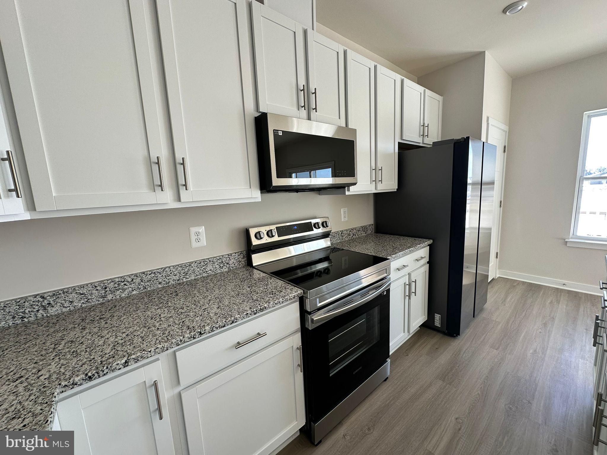 41 Sherman Avenue Ranson, WV 25438 - Photo 9 of 19 a kitchen with granite countertop a sink a stove a microwave and refrigerator