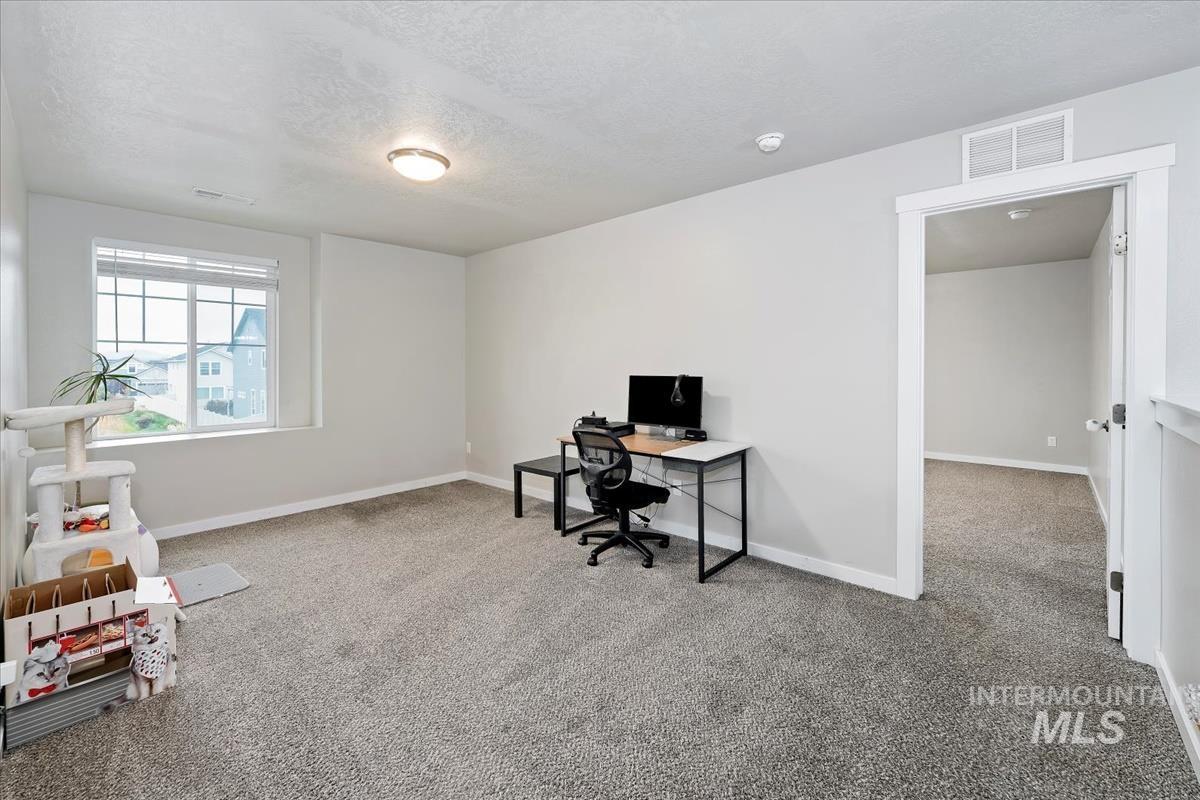 4585 West Everest Street Meridian, ID 83646 - Photo 27 of 37 Home office with light carpet and a textured ceiling