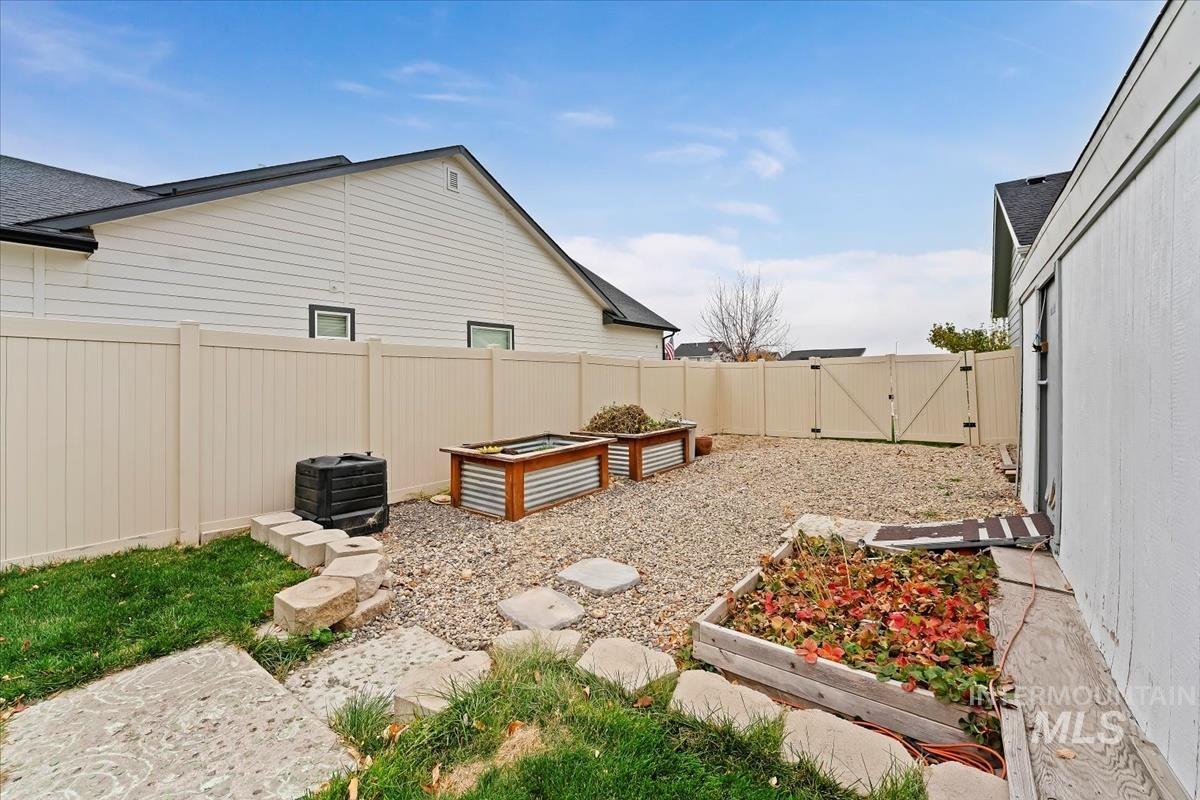 4585 West Everest Street Meridian, ID 83646 - Photo 35 of 37 Fenced backyard with a vegetable garden and a gate