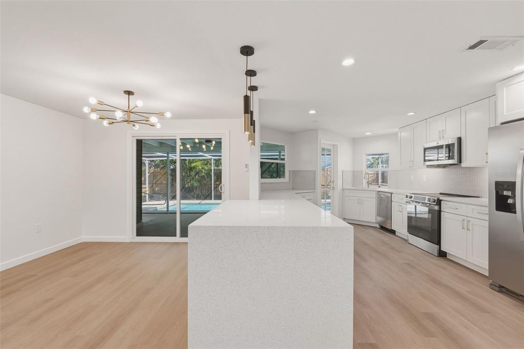 1330 Horizon Road Venice, FL 34293 - Photo 16 of 40 a living room with stainless steel appliances kitchen island furniture and a chandelier