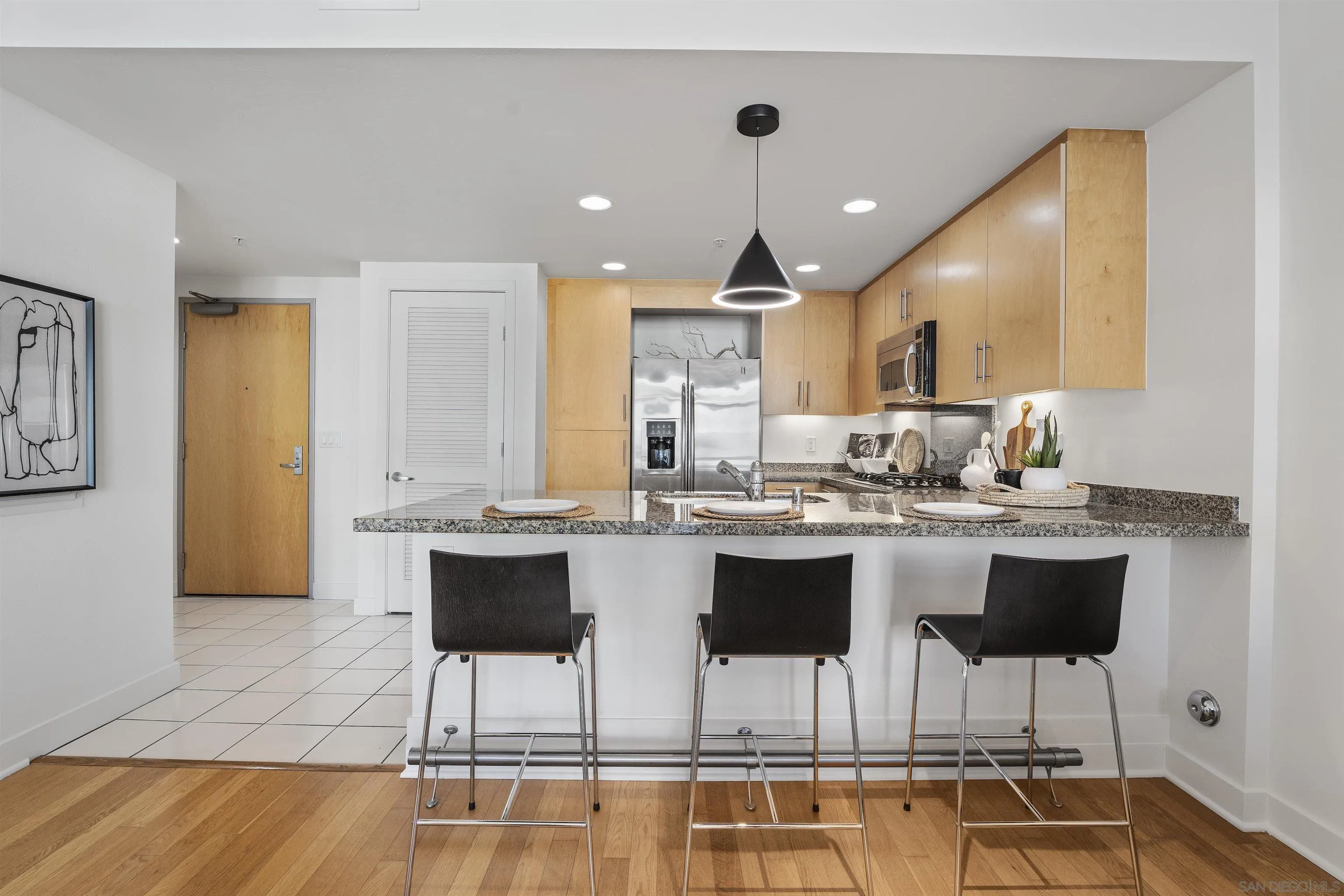 3812 Park Boulevard, Unit 412 San Diego, CA 92103 - Photo 6 of 24 a kitchen with a dining table chairs sink and cabinets