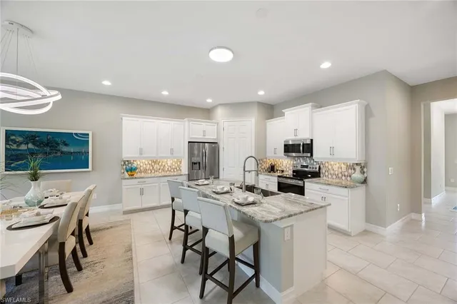 a kitchen with a dining table chairs stove refrigerator and living room view
