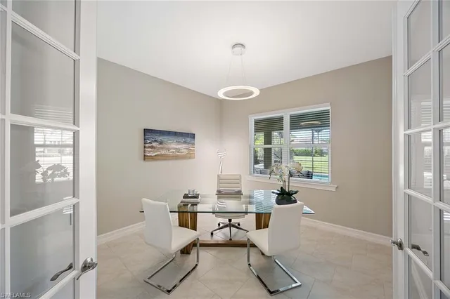 a workspace with white walls and a window