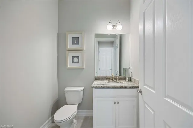 a bathroom with a sink vanity mirror and toilet