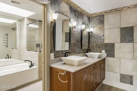 a bathroom with a granite countertop sink mirror and a bathtub