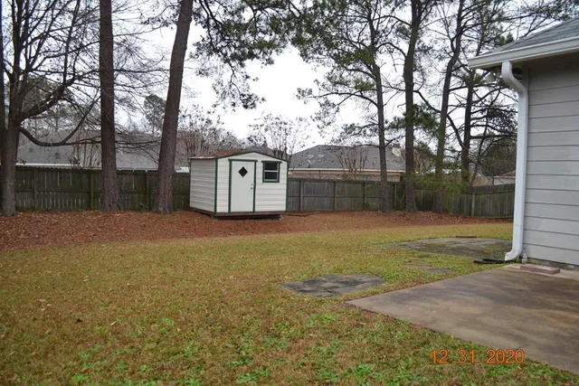 a view of a backyard with large trees