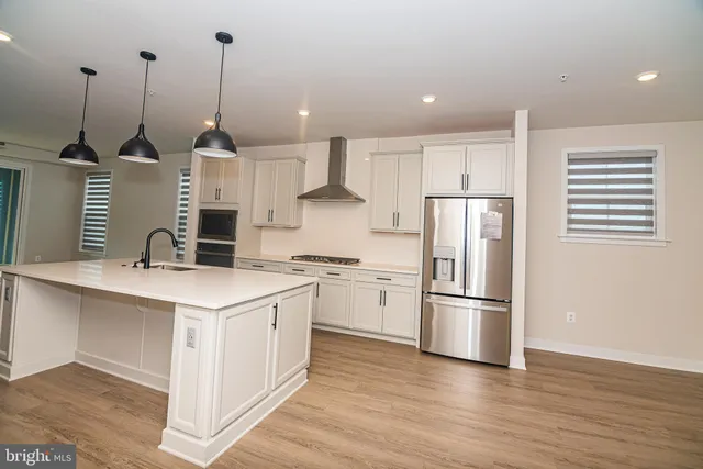 a kitchen with kitchen island white cabinets and stainless steel appliances