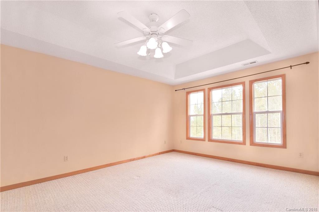 6290 Stokes Ferry Road Salisbury, NC 28146 - Photo 18 of 28 an empty room with windows and chandelier fan