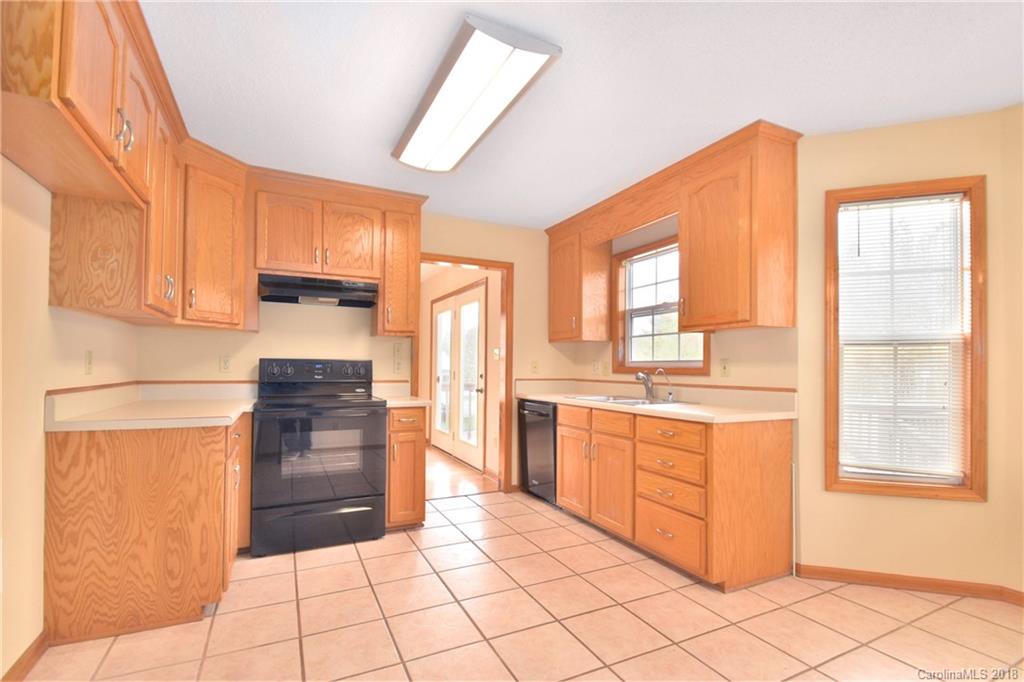 6290 Stokes Ferry Road Salisbury, NC 28146 - Photo 9 of 28 a kitchen with stainless steel appliances kitchen island granite countertop a refrigerator and a stove top oven