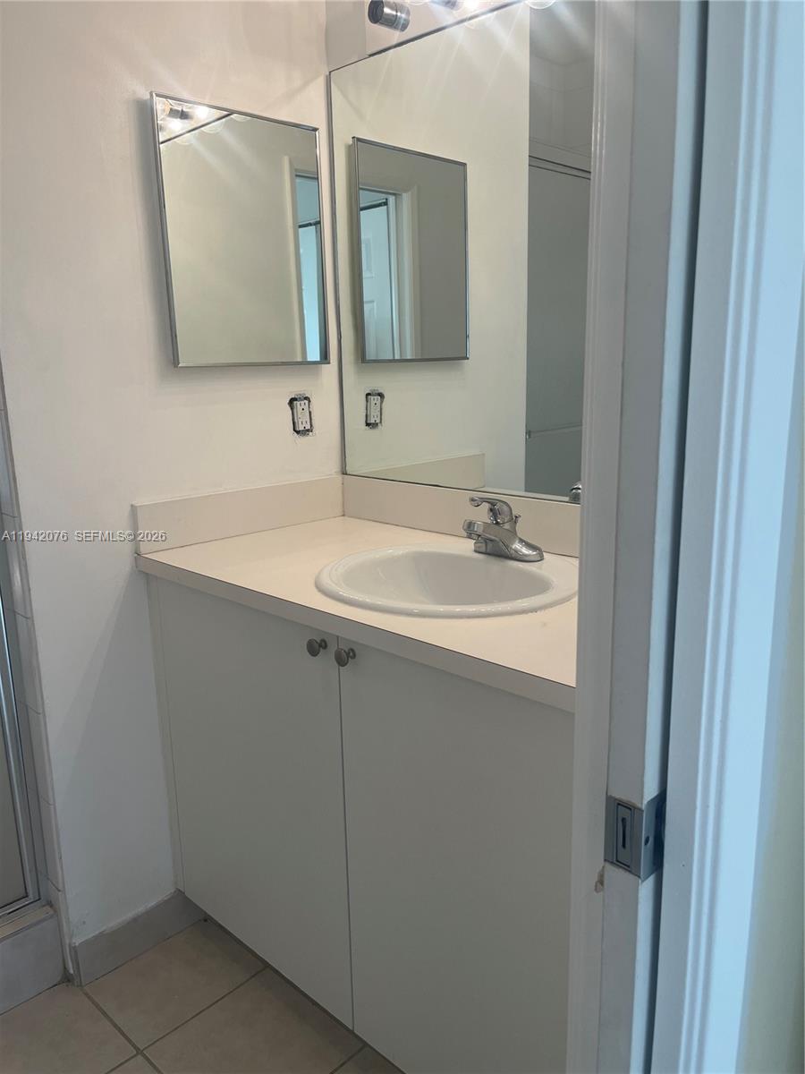 8060 North Nob Hill Road, Unit 305 Tamarac, FL 33321 - Photo 4 of 4 a bathroom with a sink and a mirror