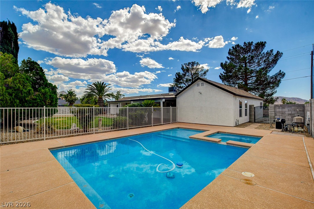 1810 Pinto Road Henderson, NV 89002 - Photo 2 of 53 An inviting backyard oasis features a glistening pool with an integrated spa, perfect for relaxation.