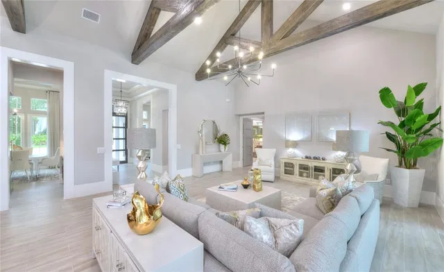 a living room with furniture kitchen and a chandelier