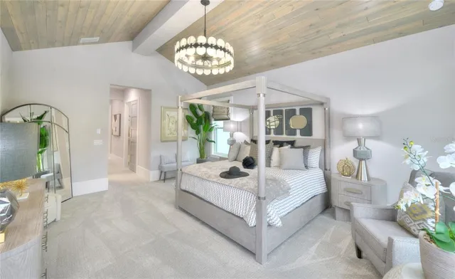 a spacious bedroom with a bed a chandelier and mirror