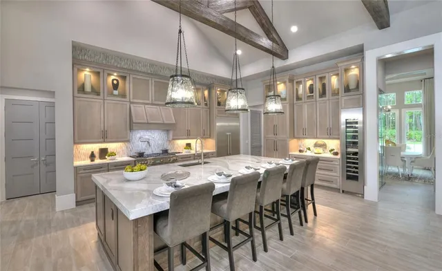 a dining room with stainless steel appliances kitchen island granite countertop a table chairs and a kitchen view